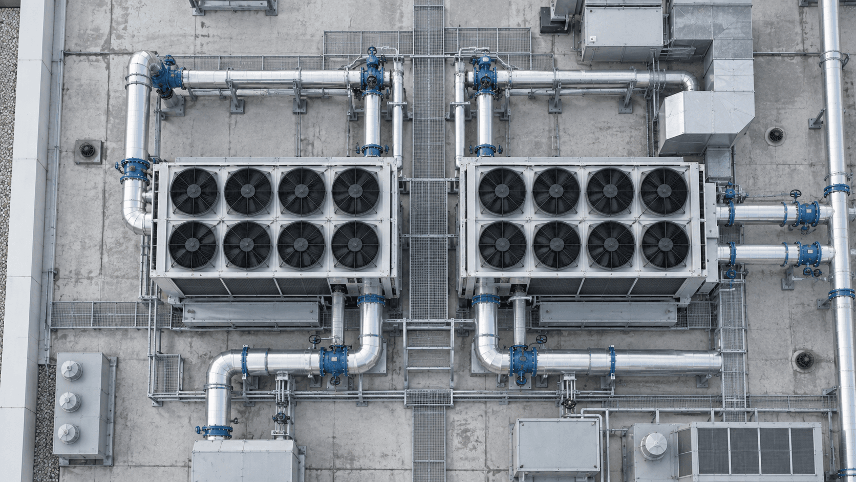 Overhead view of rooftop chillers, fans, and service walkways at a commercial office building