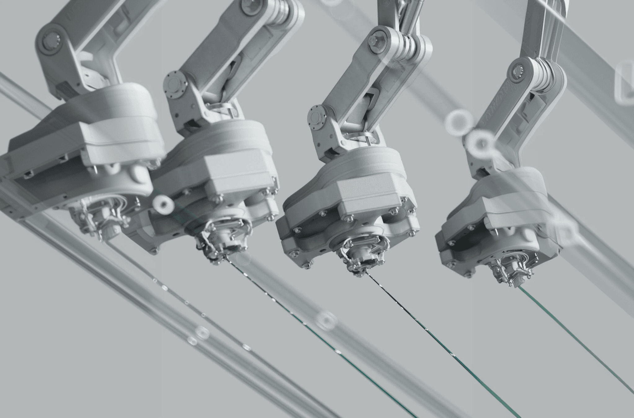 A row of robotic arms mounted along an overhead gantry on an assembly line